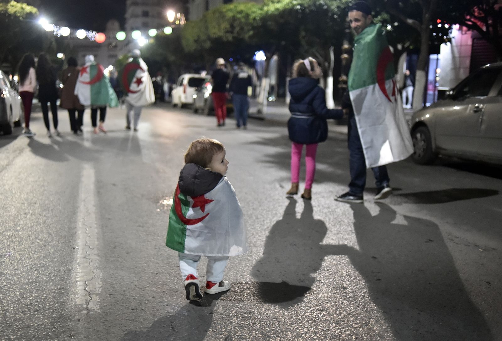 AFP-เด็กคลุมธงชาติแอลจีเรีย-ผู้ชุมนุมขับไล่ ปธน.อับเดลาซิส บูเตฟลิกา แยกย้ายกลับบ้านหลังมีการประกาศลาออก.jpg