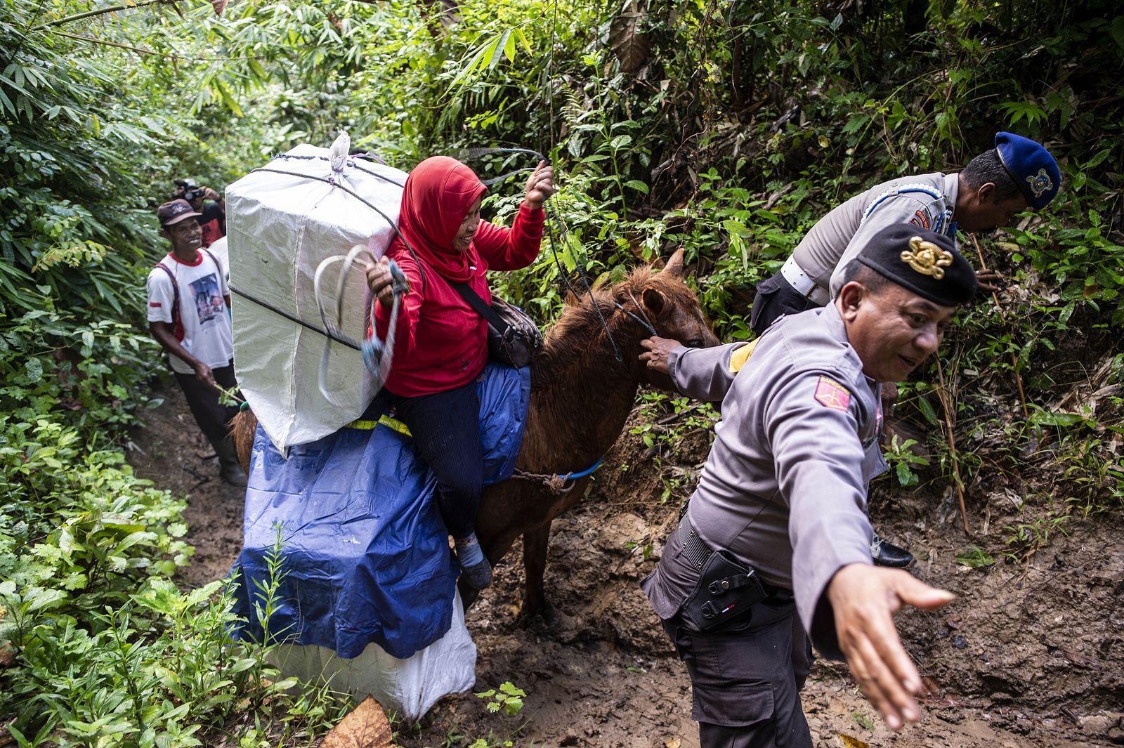 AFP-ตำรวจช่วยเจ้าหน้าที่ กกต.ขนบัตรเลือกตั้งด้วยการขี่ม้าขึ้นเขาไปยังหมู่บ้านเจมเบอร์ จ.ชวาตะวันออกของอินโดนีเซีย.jpg